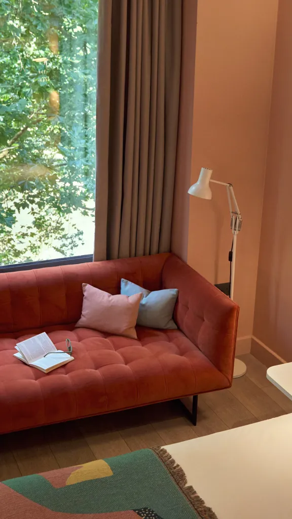 vibrant orange sofa near a huge window glass at Second Nature Southampton Hometel
